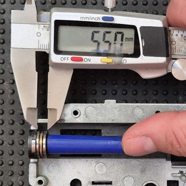 Measuring the spring guide bearing thickness with calipers